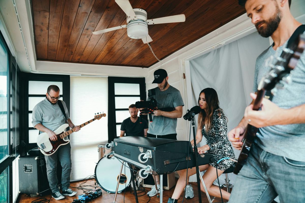 Band being filmed in a bright room for an “as live” music video