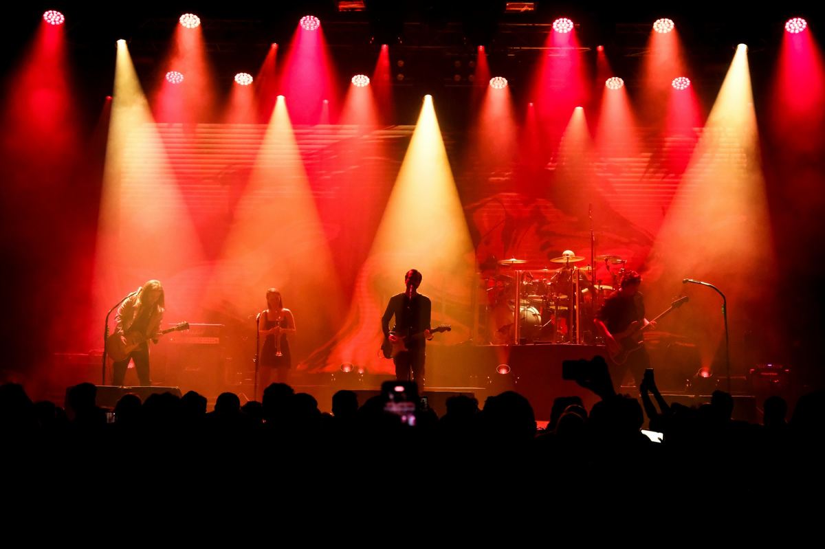 Band on stage under red and gold stage lights at a gig