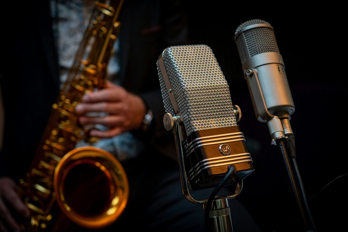 Saxophonist beside vintage microphones